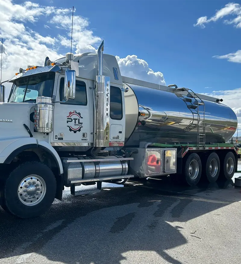 environmental-vacuum-truck-fluid-hauling Large chrome and white vacuum tanker truck designed for environmental fluid management and drilling mud hauling parked on an asphalt lot.